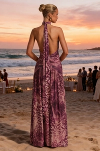Detail view of the open-back purple leopard print maxi dress at a sunset beach party