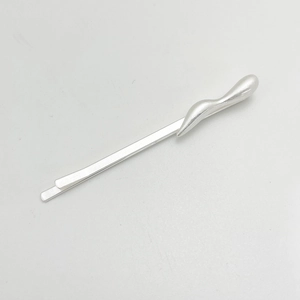Macro view of minimalist silver irregular metal hair clip with a sleek wavy design