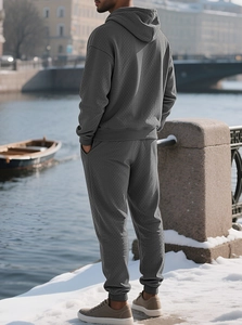 Detail of men's dark grey hooded tracksuit showing premium knitted diamond texture pattern