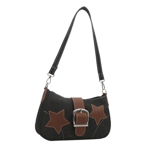 Detailed shot of black denim shoulder bag with brown star patches and metal buckle
