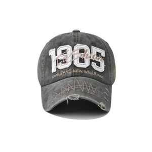Close-up of vintage 1985 embroidery and distressed brim details on a washed cotton cap