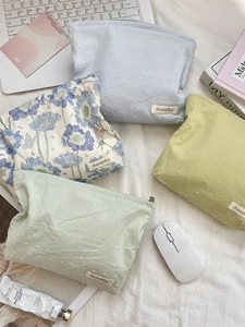 Floral print and textured polka dot makeup bags set in a cozy office desk setting