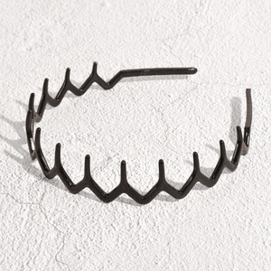 Detail of black wavy zigzag headband with smooth metallic texture for hair styling