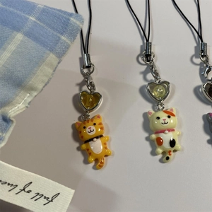 Close-up of cute Y2K tabby and calico cat keychains with metal clasps and black lanyards