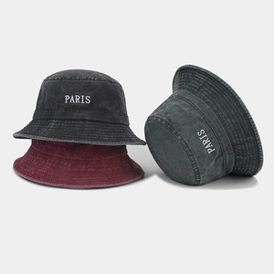 Detail of washed cotton bucket hats in black, wine red, and dark grey with PARIS embroidery