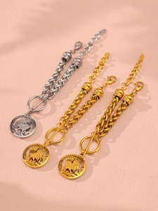 Detailed view of vintage gold and silver chain bracelets with rooster coin pendants