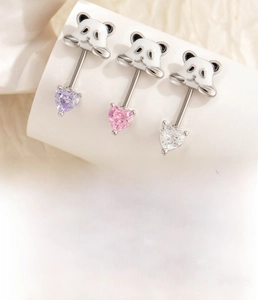 Dettaglio degli orecchini a panda con zirconi a forma di cuore viola e rosa