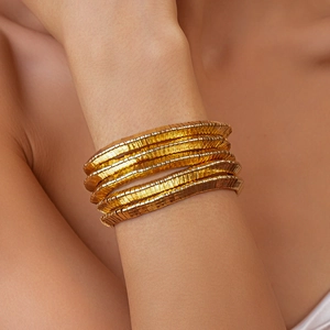 Close-up of gold multi-layer coiled tubogas bracelet with sleek spiral metal texture