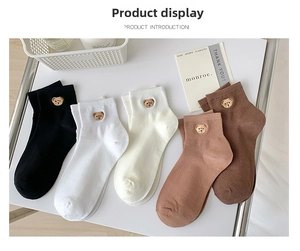Close-up of cute teddy bear embroidery on various colored cotton ankle socks