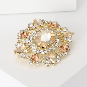 Macro shot of oval champagne crystal brooch with intricate gold metal filigree design