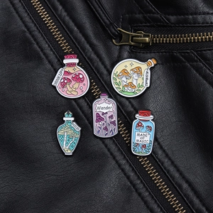 Detail of magic potion bottle and mushroom enamel pins on a black leather jacket