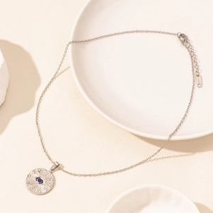 Detail showing the S.STEEL engraving and blue evil eye pendant on a starburst necklace