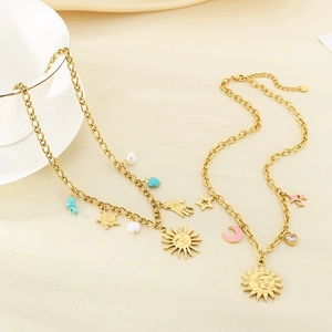 Gold sun star moon necklaces with pearl pendants on a soft beige fabric background