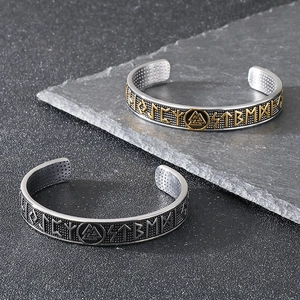 Close-up of Nordic Viking rune bangles with dotted interior on dark stone background