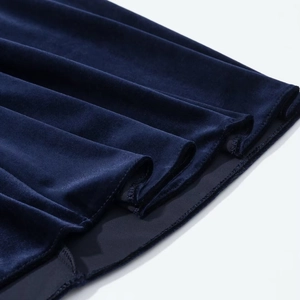 Detail of navy blue velvet dress showing hem stitching and soft fabric texture