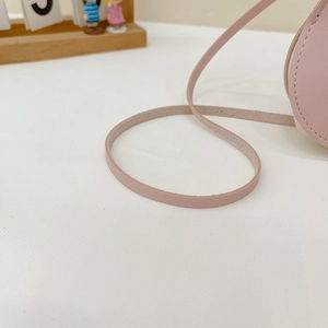 Close-up of pink faux leather shoulder strap with smooth edges and durable texture