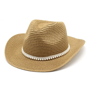 Détail du chapeau de cowboy en paille à large bord avec bandeau de perles décoratif