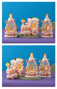 Macro detail of gingerbread Christmas train and lit snow globe ornaments for desktop decor