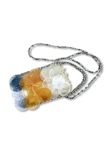 Detailaufnahme handgewebter Muschelscheiben und Silberkette an dieser eleganten Tasche