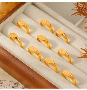 Lot de neuf chevalières dorées en acier titane avec numéros chance dans un coffret en bois