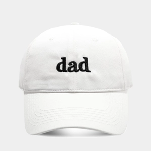 Detail of white cotton baseball cap featuring black embroidered dad logo and curved brim