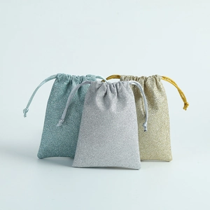 Detailed view of drawstring gift bags in sparkling blue, silver, and gold metallic fabric