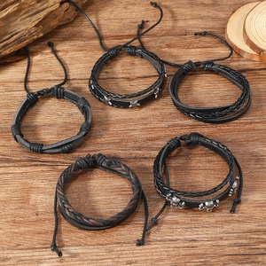 Set di bracciali in pelle punk da uomo con teschio e stelle su sfondo in legno