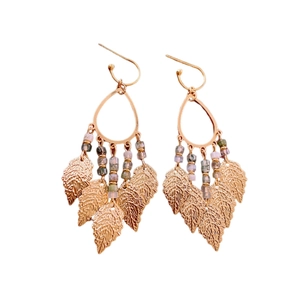 Golden drop hoop earrings with hanging textured leaf tassels and purple bead accents