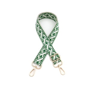 Détail de la bandoulière tissée vert et blanc avec attaches en métal doré poli