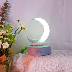Detail of crescent moon night light with star patterns and heart-shaped base switch