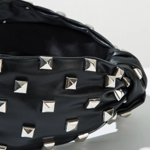Macro detail of black leather headband with studded silver pyramid metal rivets