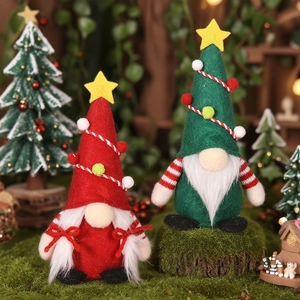 Lot de nains de Noël en peluche avec chapeaux rouges et verts sur fond de mousse