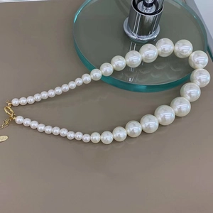Collier de perles dégradées vintage français avec fermoir doré sur fond beige