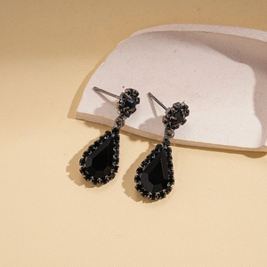 Detail of dark vintage waterdrop earrings with black faceted gemstones and gothic accents