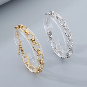 Minimalist gold and silver stainless steel cable chain bracelets on acrylic display