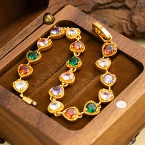 Detailed shot of multi-colored heart gemstone bracelet inside a premium wooden jewelry box
