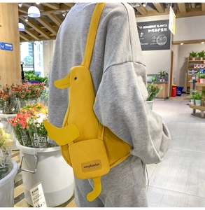 Detail of creative yellow duck crossbody bag with 3D wings and feet in a cozy flower shop