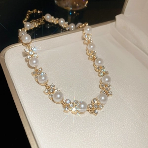 Dettaglio della collana a fiori con perle bianche e strass scintillanti nella scatola
