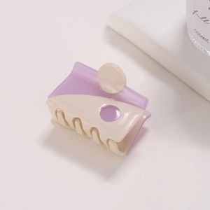 Close-up of square acetate hair claw clip in beige and purple yin-yang color block design