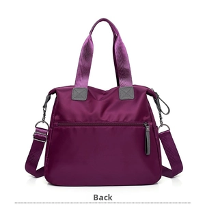 Detail view of the purple travel bag back with secure zipper pocket and shoulder strap