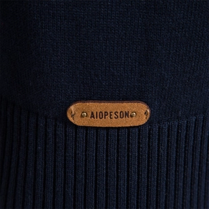 Men's navy blue knit sweater featuring stand collar and brown leather logo patch details