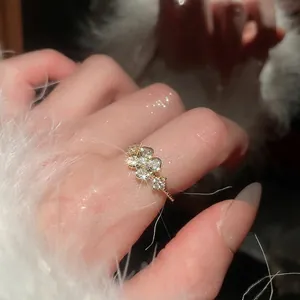 Elegant gold flower ring with sparkling zircon stones and beaded texture on model finger