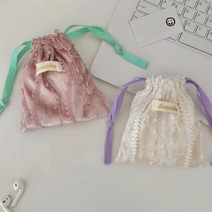 Close-up of lace-trimmed drawstring pouches in pink and cream with Sozakka embroidery