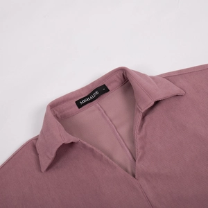 Detail of mauve corduroy dress showing the sharp collar, V-neckline, and label