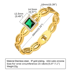 Détail d'un bracelet doré avec chiffres romains, zircon vert et texture tissée