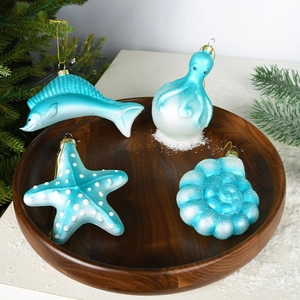 Blue ocean-themed glass Christmas ornaments set with octopus and starfish on wood