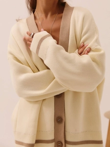 Detailed view of the V-neck knit cardigan with contrast trim and brown button accents