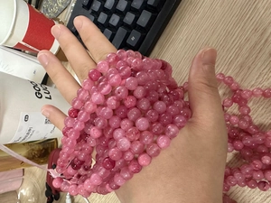 Detailed view of handmade pink chalcedony round beads for jewelry making and DIY crafts