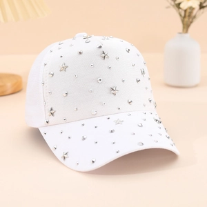White baseball cap with silver star studs and rhinestones on a minimalist background