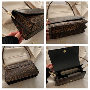 Detail view of leopard print baguette bag showing interior compartments and metal hardware